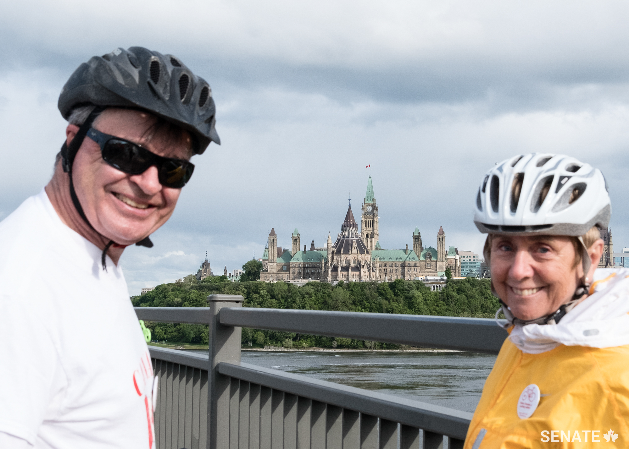 Senators Patterson and Raine share a moment with Parliament in the background.