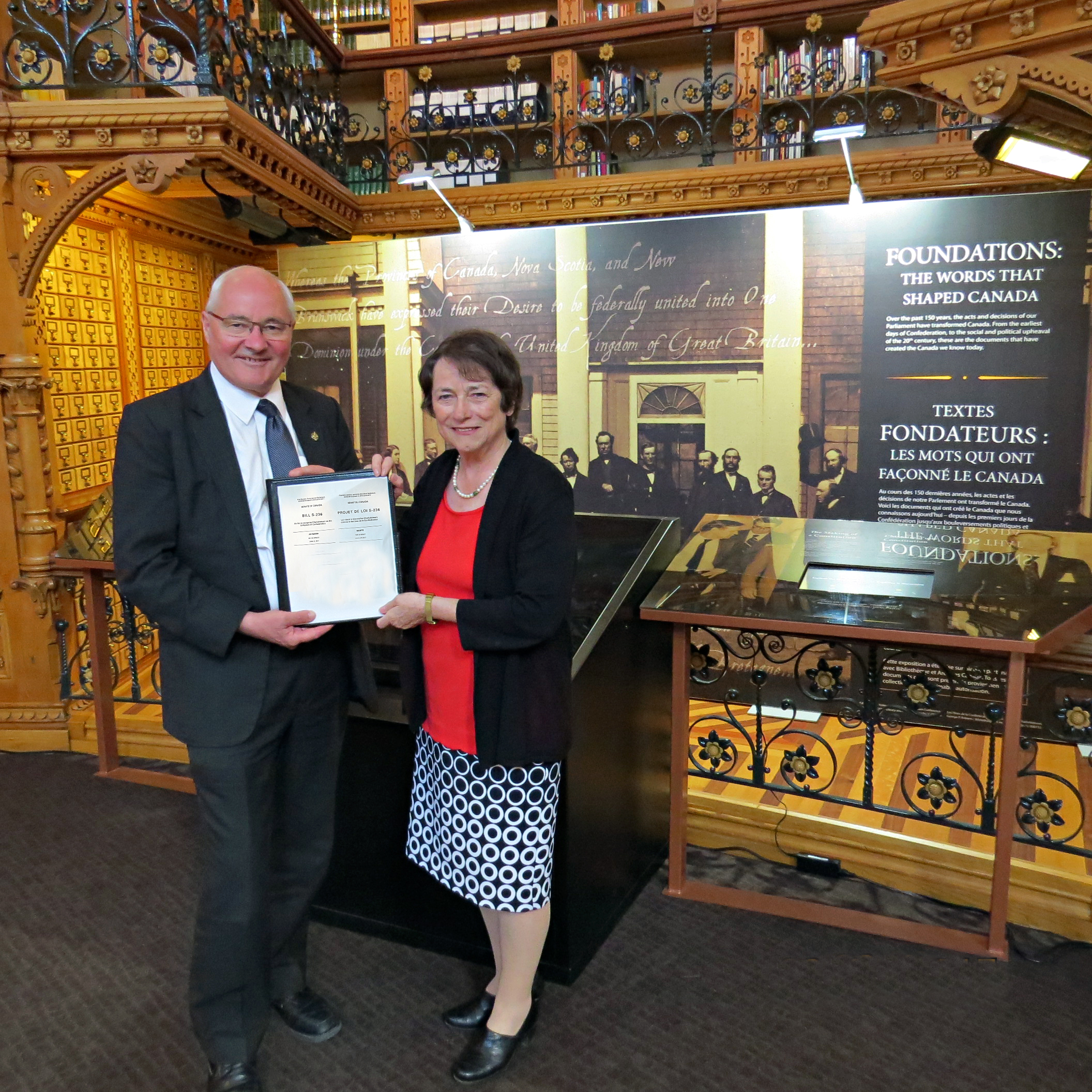 Senator Diane Griffin hands off Bill S-236, the <em>Recognition of Charlottetown as the Birthplace of Confederation Act</em>, to House of Commons sponsor MP Wayne Easter in the Library of Parliament, Ottawa.