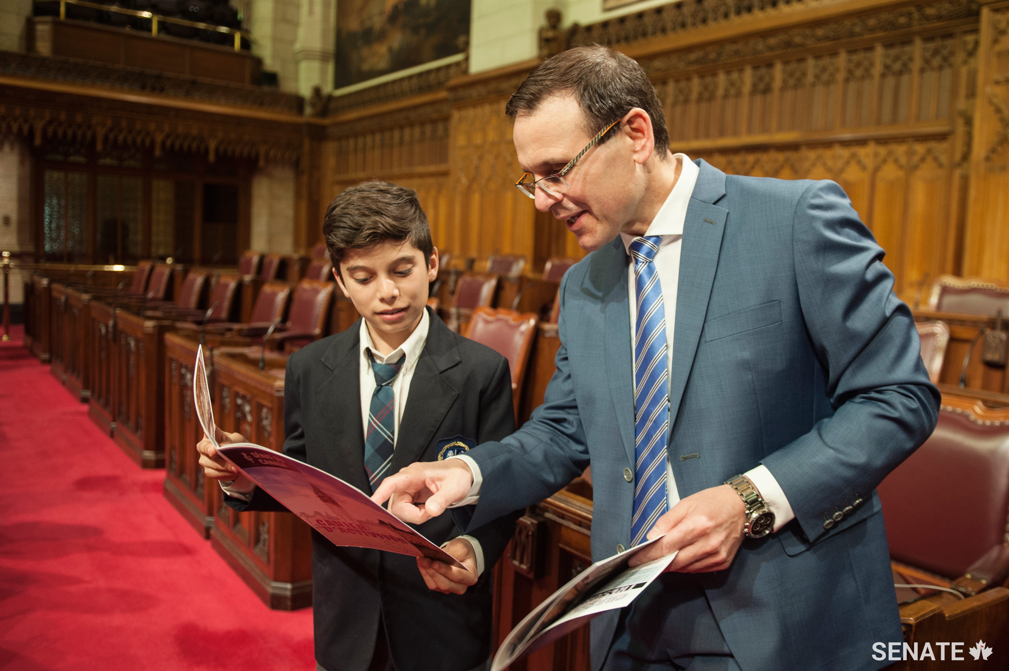 Senator Housakos compares notes with a student — some of the questions in the Senate’s new activity booklet are tough!