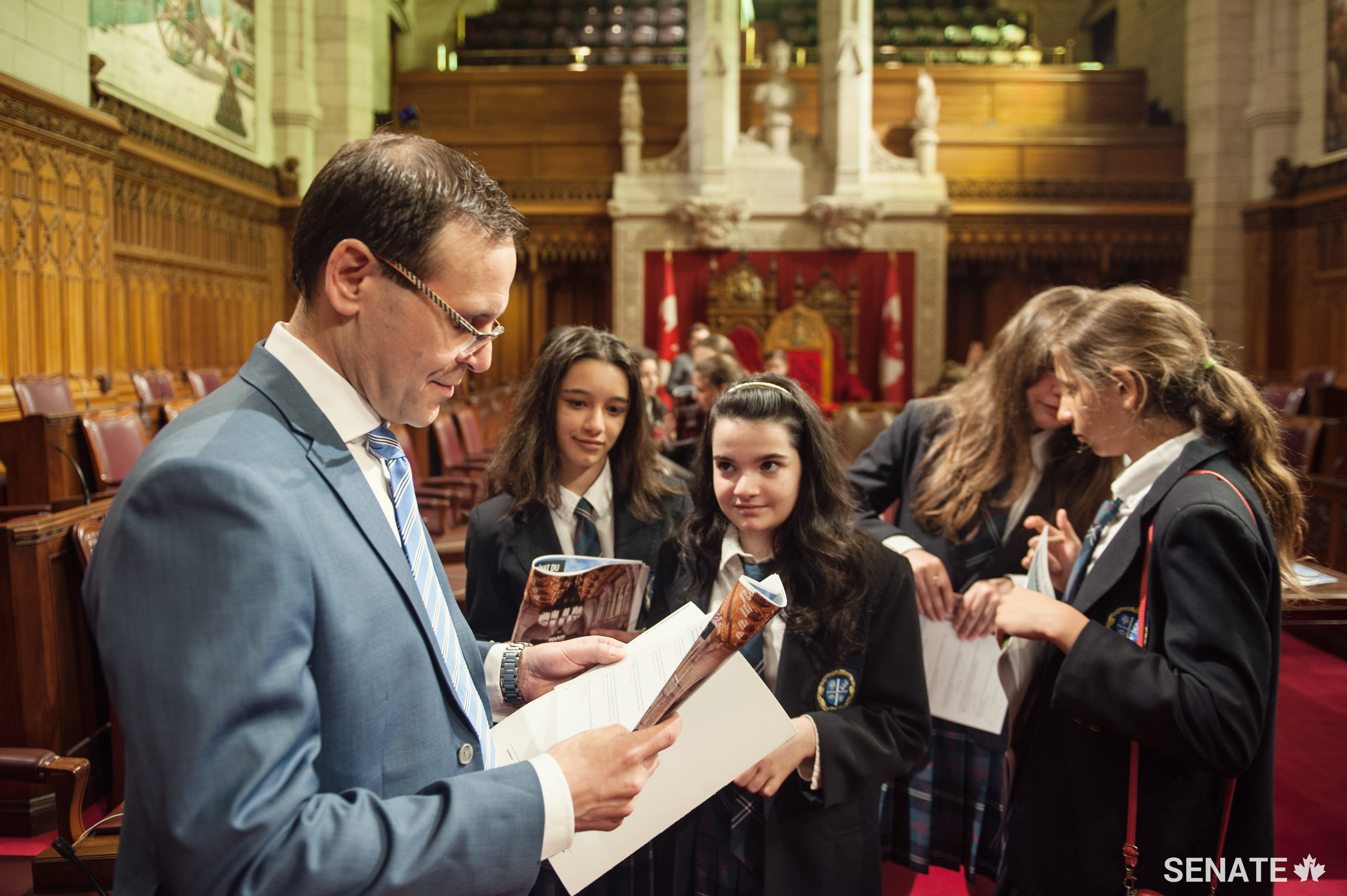 Senator Housakos helps students complete questions in a brand new Senate activity booklet.
