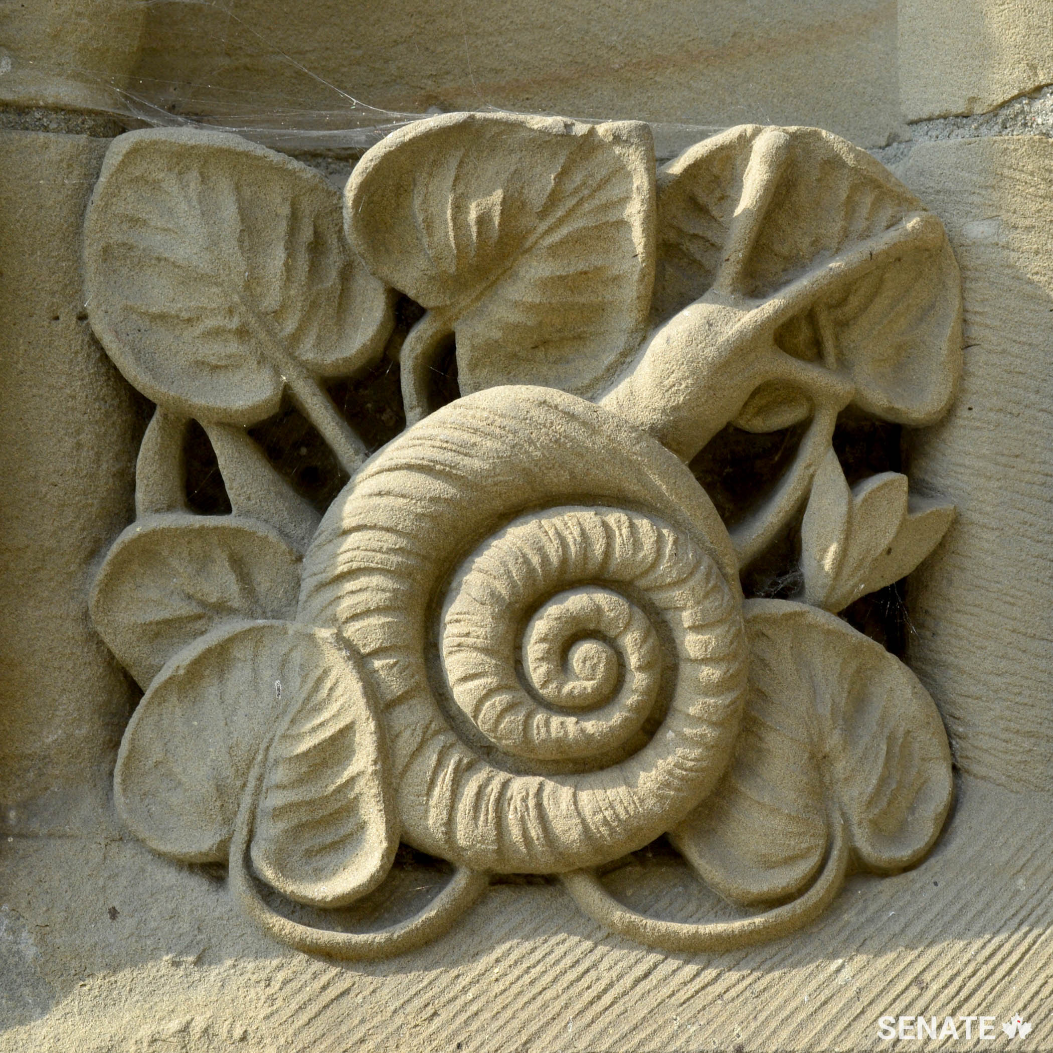 A relief panel depicting a snail adorns the base of the Peace Tower.