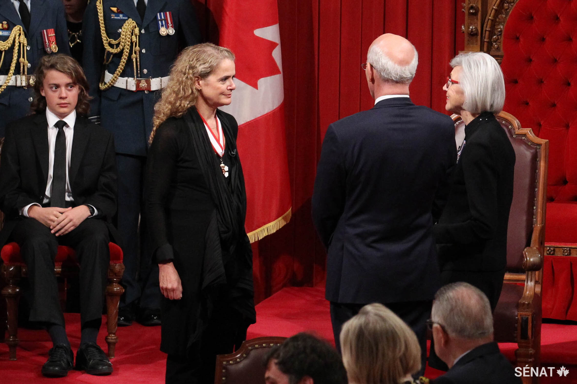 La juge en chef du Canada, Beverley McLachlin (au centre) administre les serments d’office à la gouverneure générale désignée, Julie Payette. Le fils de cette dernière, Laurier Payette Flynn, est assis tout près.