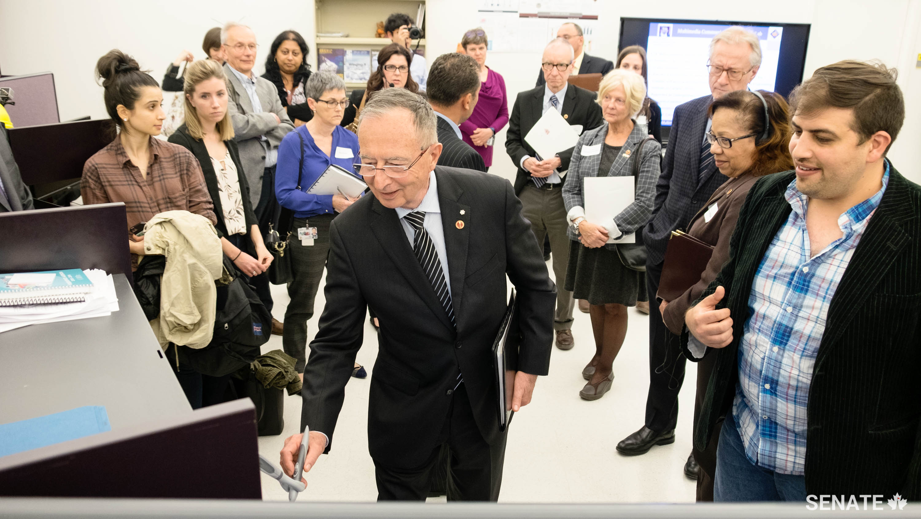 Senator Ogilvie tests a biology-inspired, mechatronic and AI-controlled pen at the BioIn Robotics Lab at the University of Ottawa.