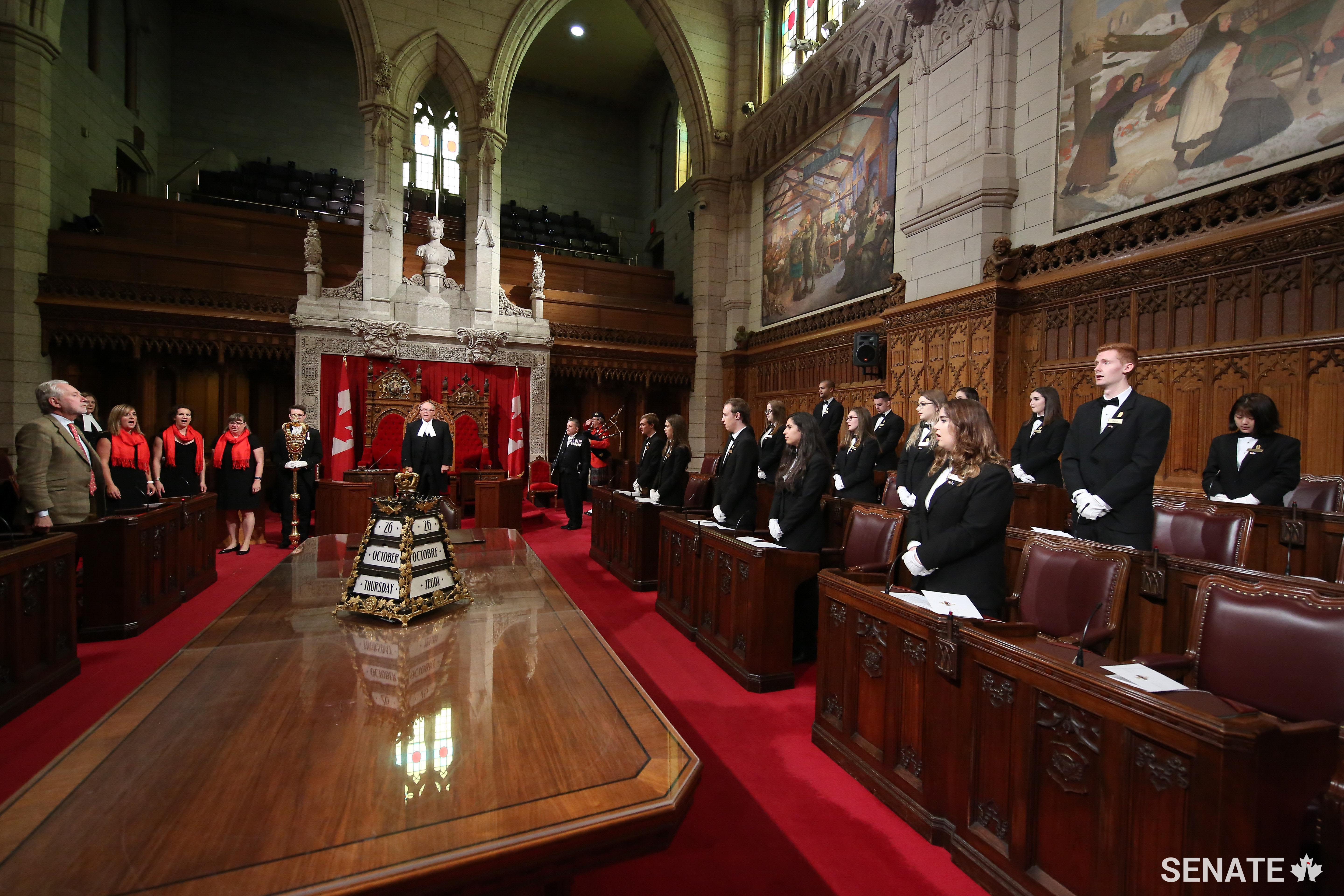 Speaker George J. Furey along with Senator Peter Harder, Government Representative in the Senate, and the Senate pages rise for a singing of the national anthem before taking their oaths to Queen and country.