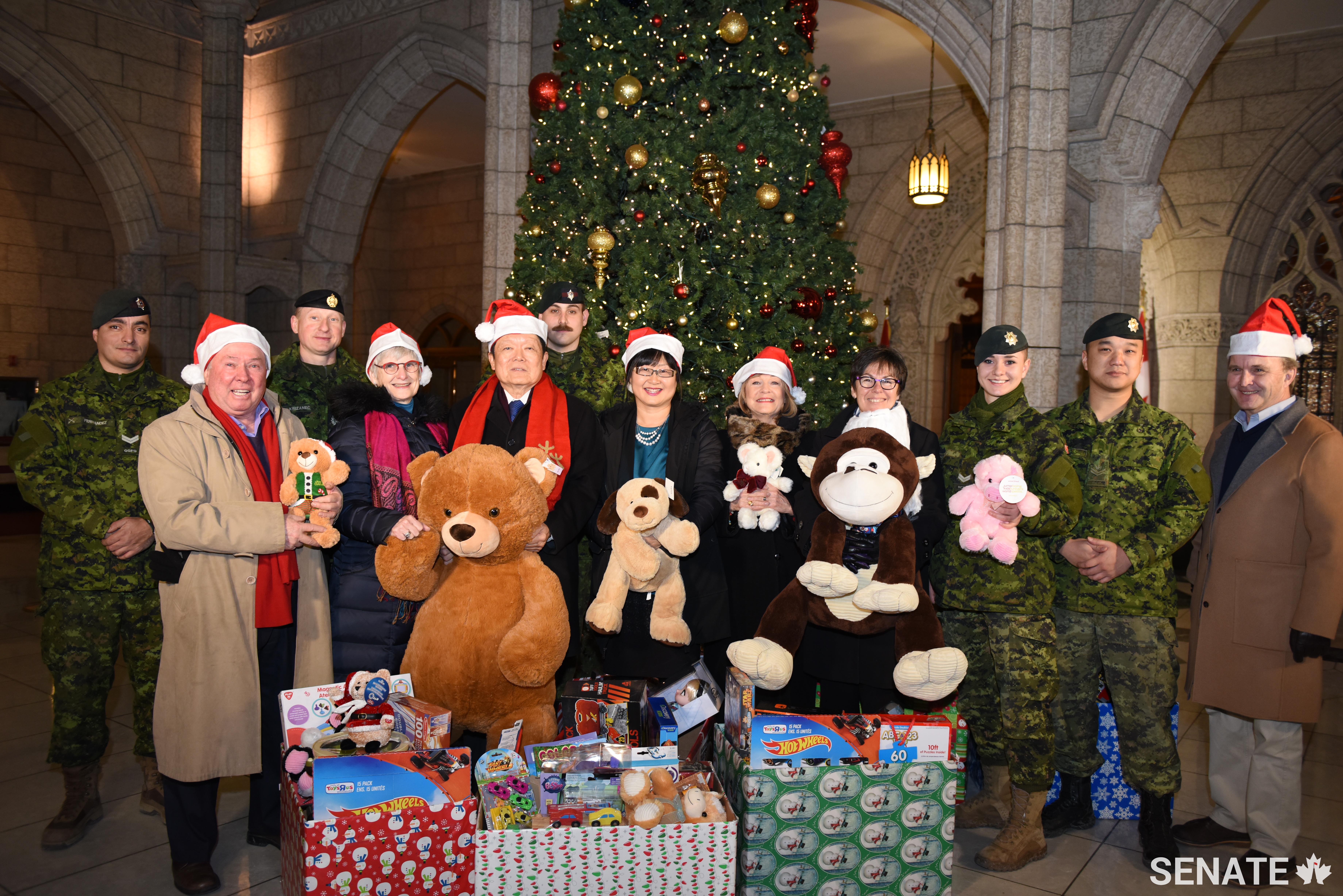 From left, senators Jim Munson, Patricia Bovey, Victor Oh, Yonah Martin, Diane Bellemare, Kim Pate and Grant Mitchell are joined by members of the Canadian Armed Forces as they gather this year’s donations.