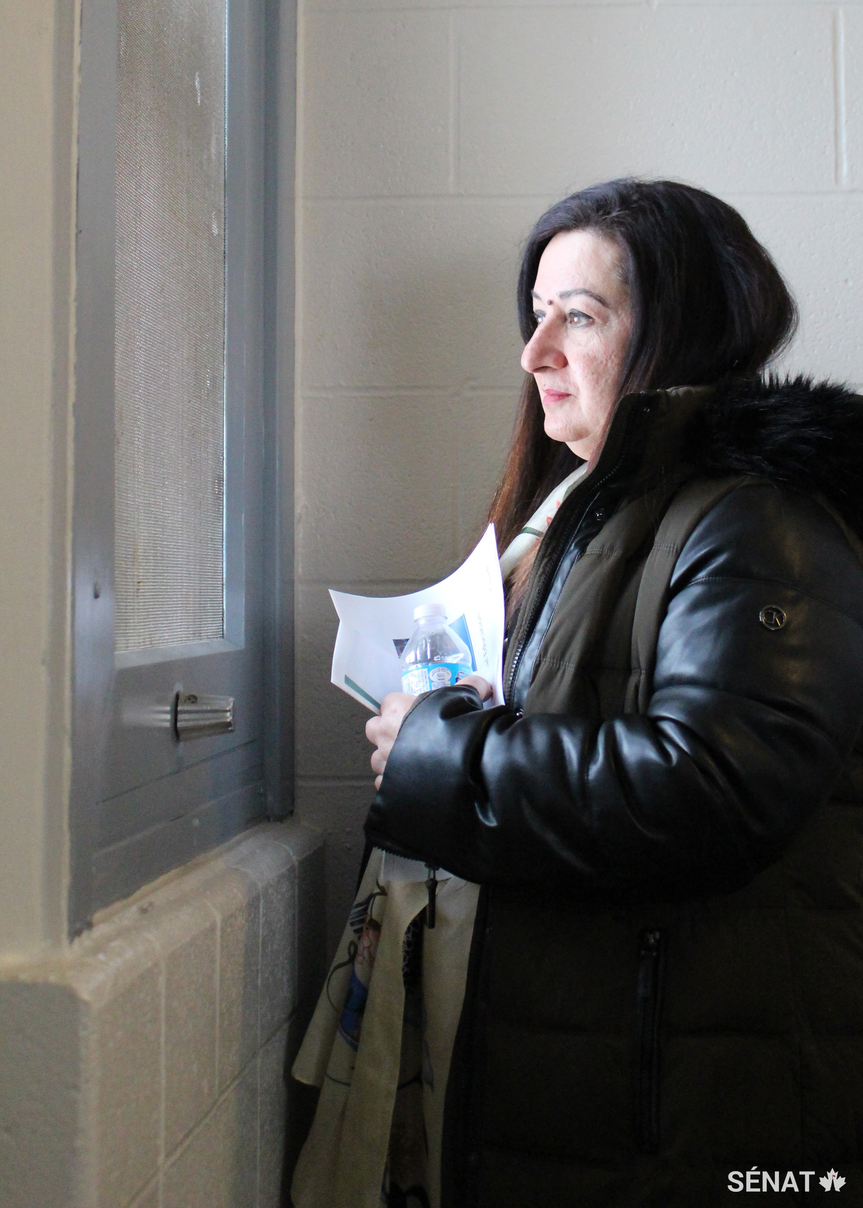 La sénatrice Salma Ataullahjan, vice-présidente du comité, regarde par la seule fenêtre donnant sur le monde extérieur dans une cellule du secteur d'isolement de la prison pour femmes Grand Valley, à Kitchener (Ontario).