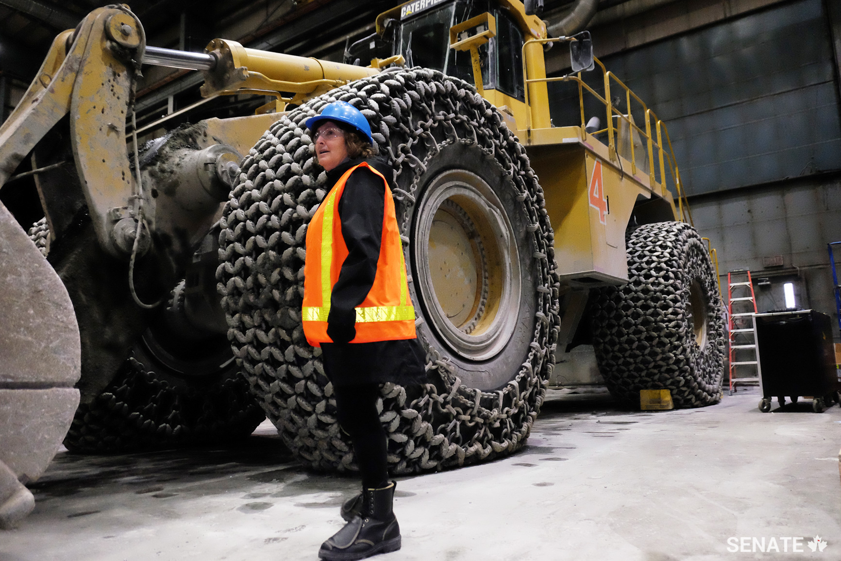 Senator Mary Coyle examines the garage at Meadowbank Mine. Behind her is a large excavator used in the mine. Many Inuit have gained valuable skills at the mine and have gone on to work in a variety of positions, including servicing heavy machinery. One Inuk worker started at the company as a janitor but became one of the mine’s top heavy equipment operators after six years of work experience and training.