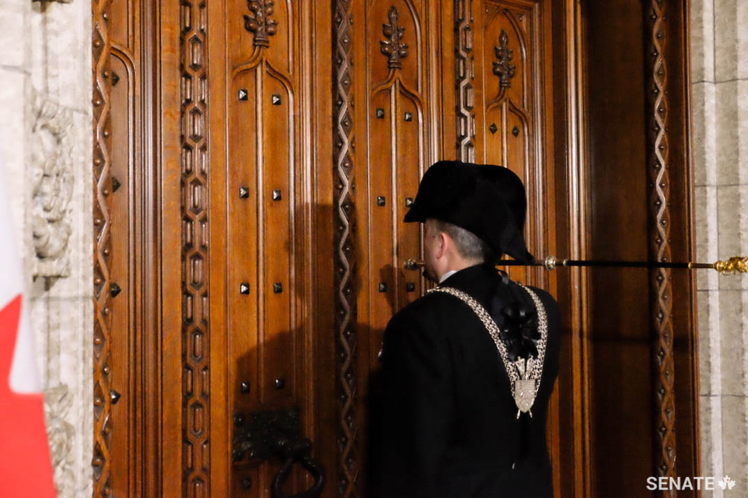 The Usher of the Black Rod uses his ceremonial staff — the black rod itself — to knock on the doors of the House of Commons Chamber three times to invite members, on the Queen’s or Governor General’s behalf, to attend an Opening of Parliament, a Speech from the Throne or a Royal Assent ceremony in the Senate Chamber.