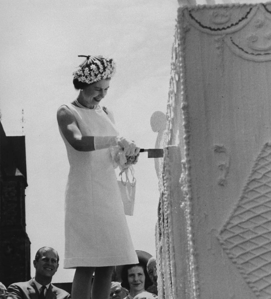 Queen Elizabeth II cuts a giant four-storey birthday cake during centennial celebrations on Parliament Hill on July 1, 1967. (Library and Archives Canada)