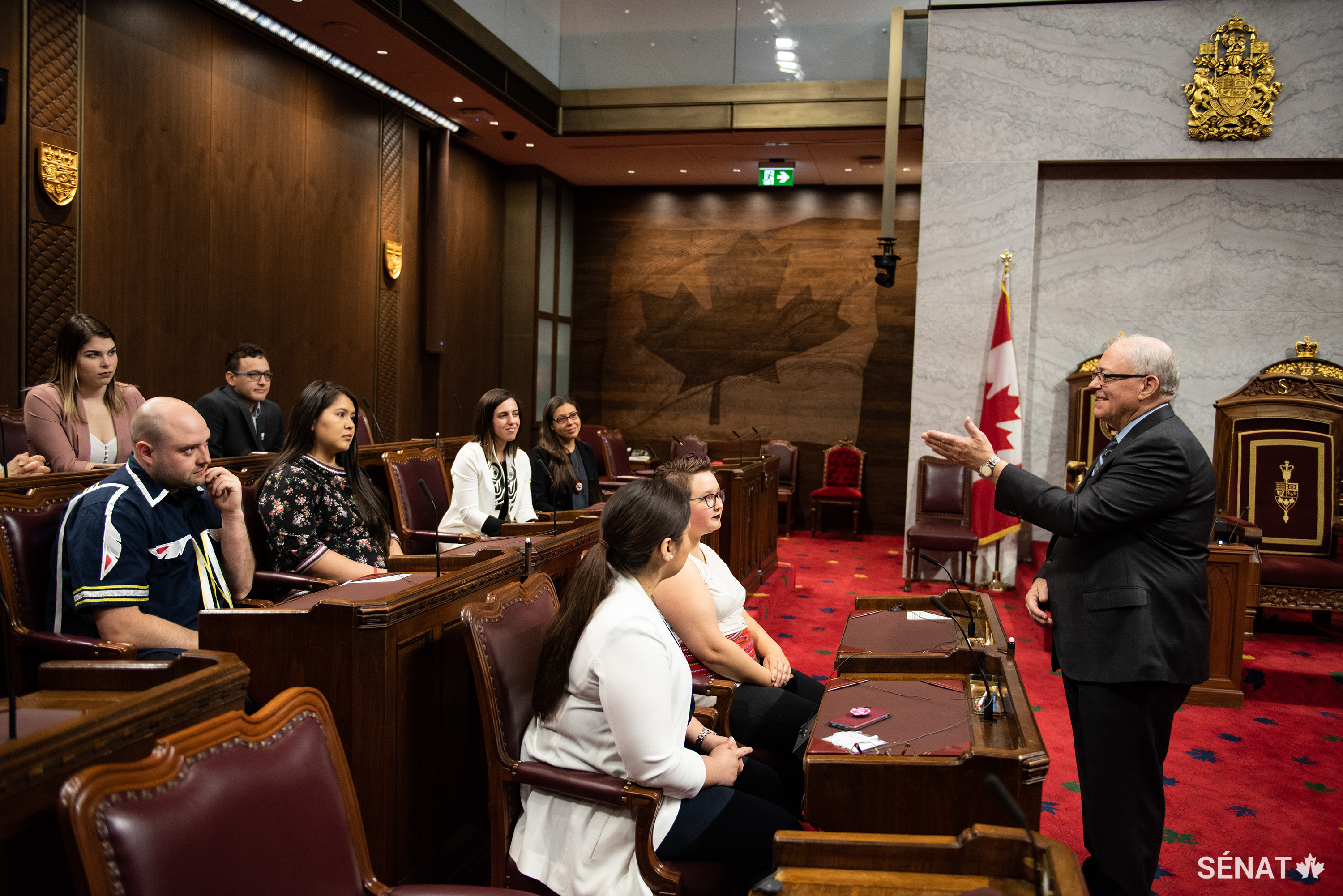 Le Président du Sénat George J. Furey parle avec les jeunes leaders autochtones lors d’un tour de la Chambre rouge le 5 juin 2019.