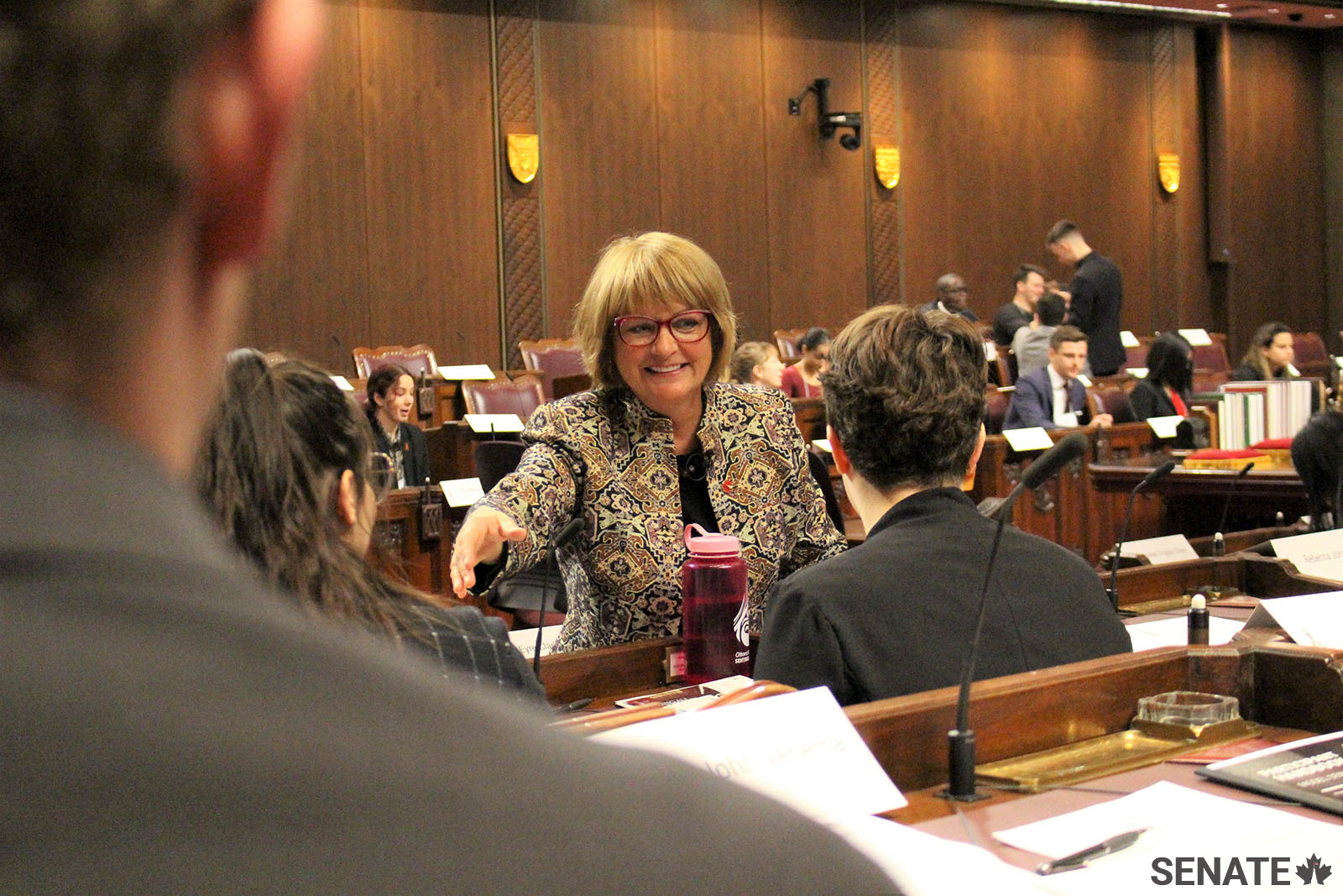 Senator Julie Miville-Dechêne greets model senators in the Red Chamber.