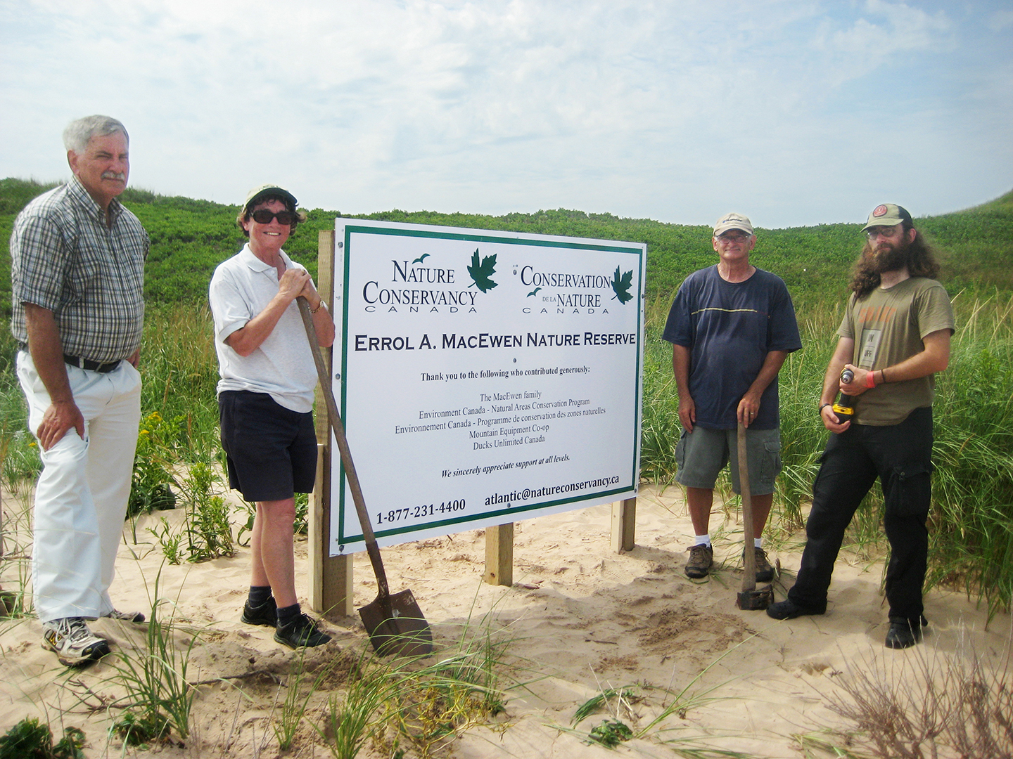 La sénatrice Diane Griffin, deuxième à gauche, aide à installer une pancarte dans les dunes de St. Peter’s Harbour, avec des membres de la famille MacEwen qui a fait don d’une parcelle de terrain à Conservation de la nature Canada en 2015.