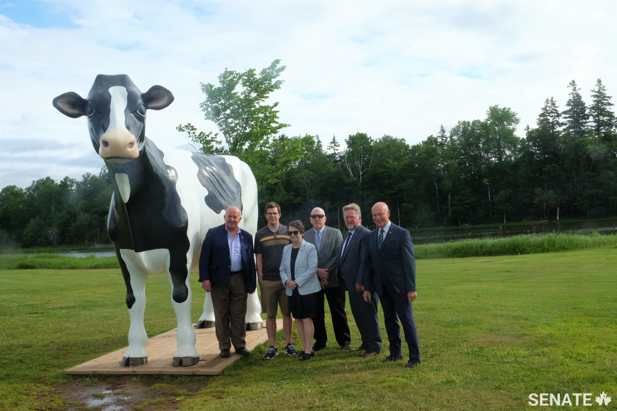 From left: Senators Terry M. Mercer, Diane Griffin, Norman Doyle, Robert Black and Jean-Guy Dagenais with COWS Creamery vice-president Chad Heron (second from left) in Charlottetown, P.E.I. on July 15, 2019.