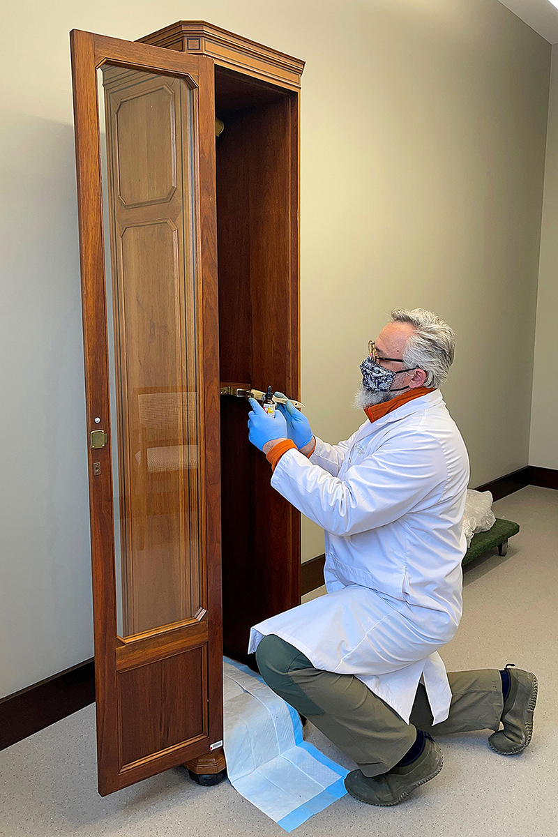 Conservator Alexander Gabov applies an acrylic clear coat to a copper-alloy bracket inside the Senate Mace cabinet. (Photo credit: Alexander Gabov)