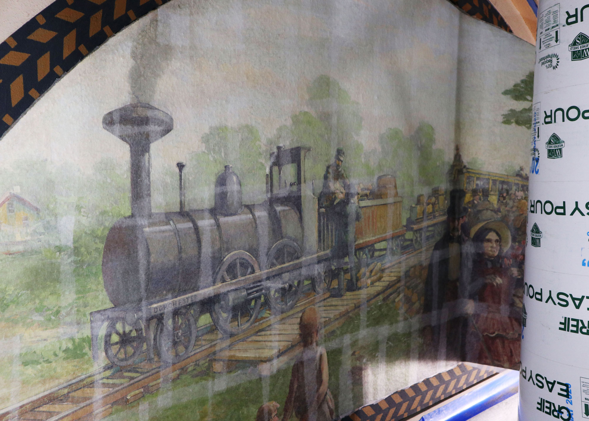 L’une des murales d’Attilio Pusterla, dont le titre non officiel est La gare, est roulée sur un tube de coffrage alors qu’elle est retirée des murs de la Salle de comité des chemins de fer du Sénat, située dans l’édifice du Centre. (Crédit photo : Legris Conservation Inc.)