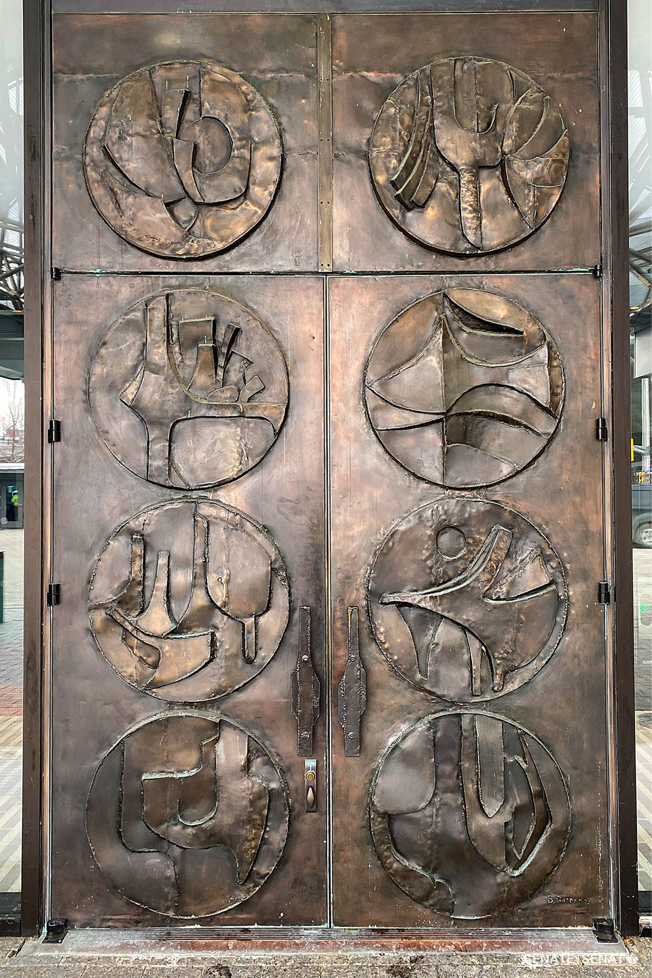 Ottawa sculptor Bruce Garner created these massive bronze doors in 1973 as Ottawa’s former downtown train station, now the Senate of Canada Building, was being renovated to become the Government Conference Centre. The eight roundels celebrate Canada’s regions with abstract depictions of landscapes and wildlife. (Bruce Garner, <em>Reflections of Canada</em>, 1973. Bronze, H: 5.5m x W: 3.5m x D: 0.5m)